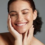 Face, beauty and satisfaction with a model black woman in studio on a gray background to promote natural skincare. Facial, wellness and makeup with an attractive young female happy with cosmetics